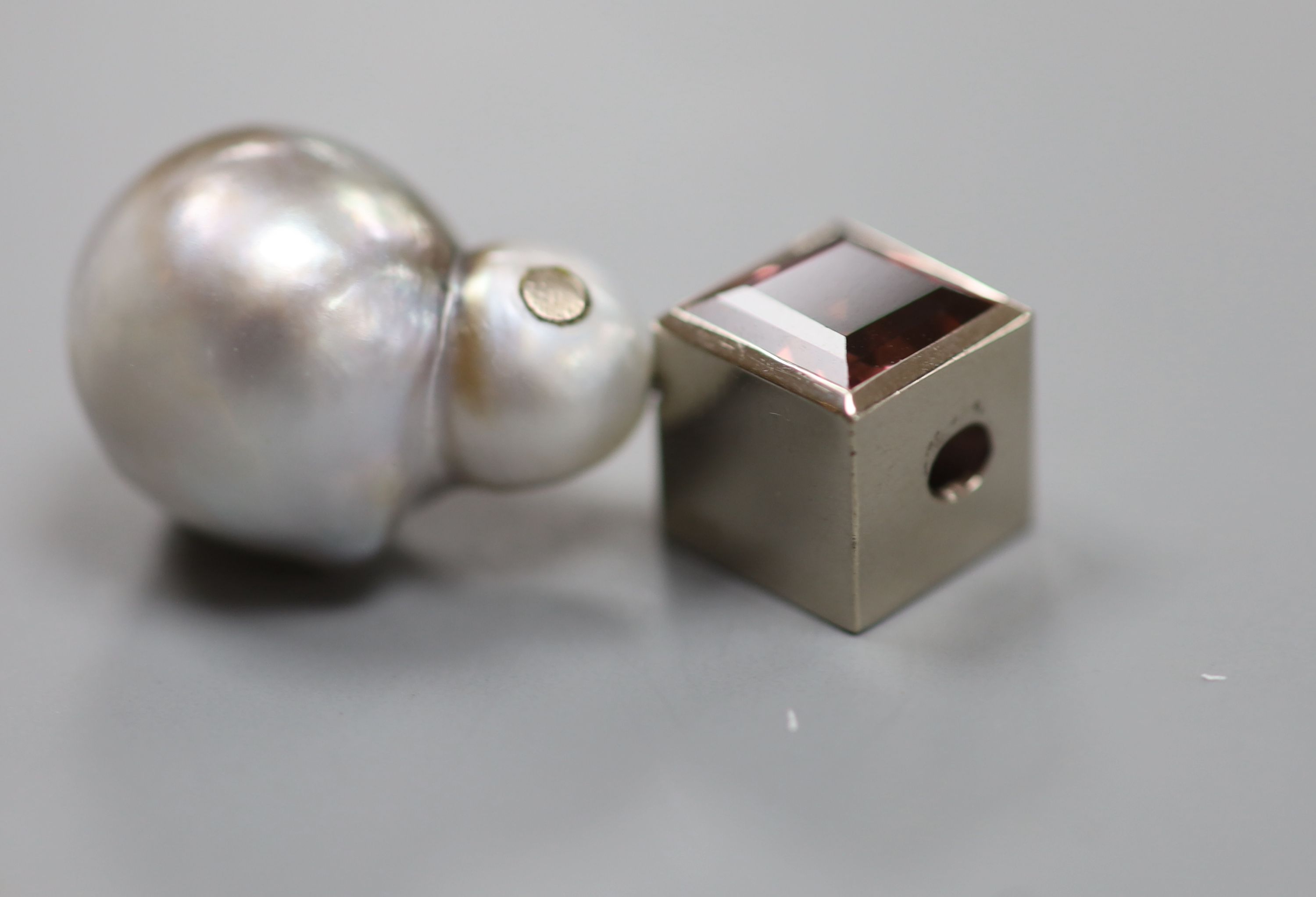 A modern 585 white metal, baroque pearl and pink tourmaline set pendant and a yellow metal cultured pearl and diamond chip set ring